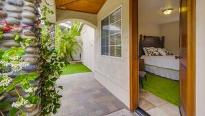 Un dormitorio con una cama, una puerta de madera y una ventana.