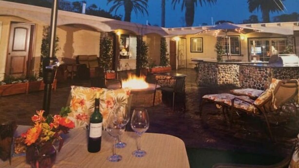 Un patio exterior con una chimenea, asientos y una zona de bar.