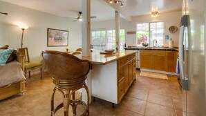 Una cocina amplia con una isla central, armarios de madera y un refrigerador.