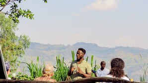 A group of people standing outdoors with a mountainous backdrop. - Frama Nature Adventure (Rugarama)