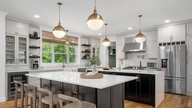 A modern kitchen with a large island, stainless steel appliances, and pendant lighting. - Woodland View (Smithfield)