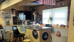 A bar area with wooden bar stools, a Coors Light sign, and a CB Craft Brewers logo. - Charming 2-bedroom vacation home 17 minutes from Watkins Glen International (Rock Stream)