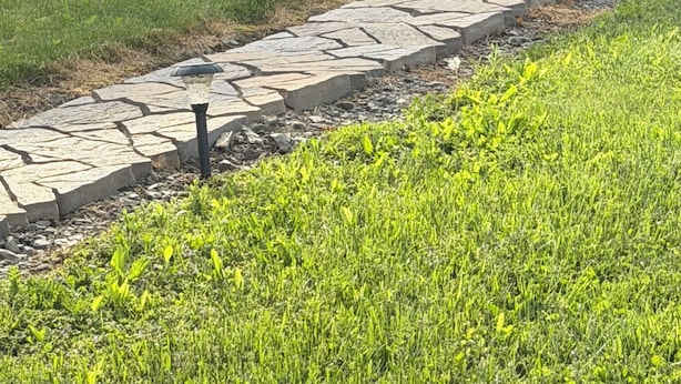 A stone pathway leading to a stone house with a wooden door and potted flowers. - Charming 2-bedroom vacation home 17 minutes from Watkins Glen International (Rock Stream)