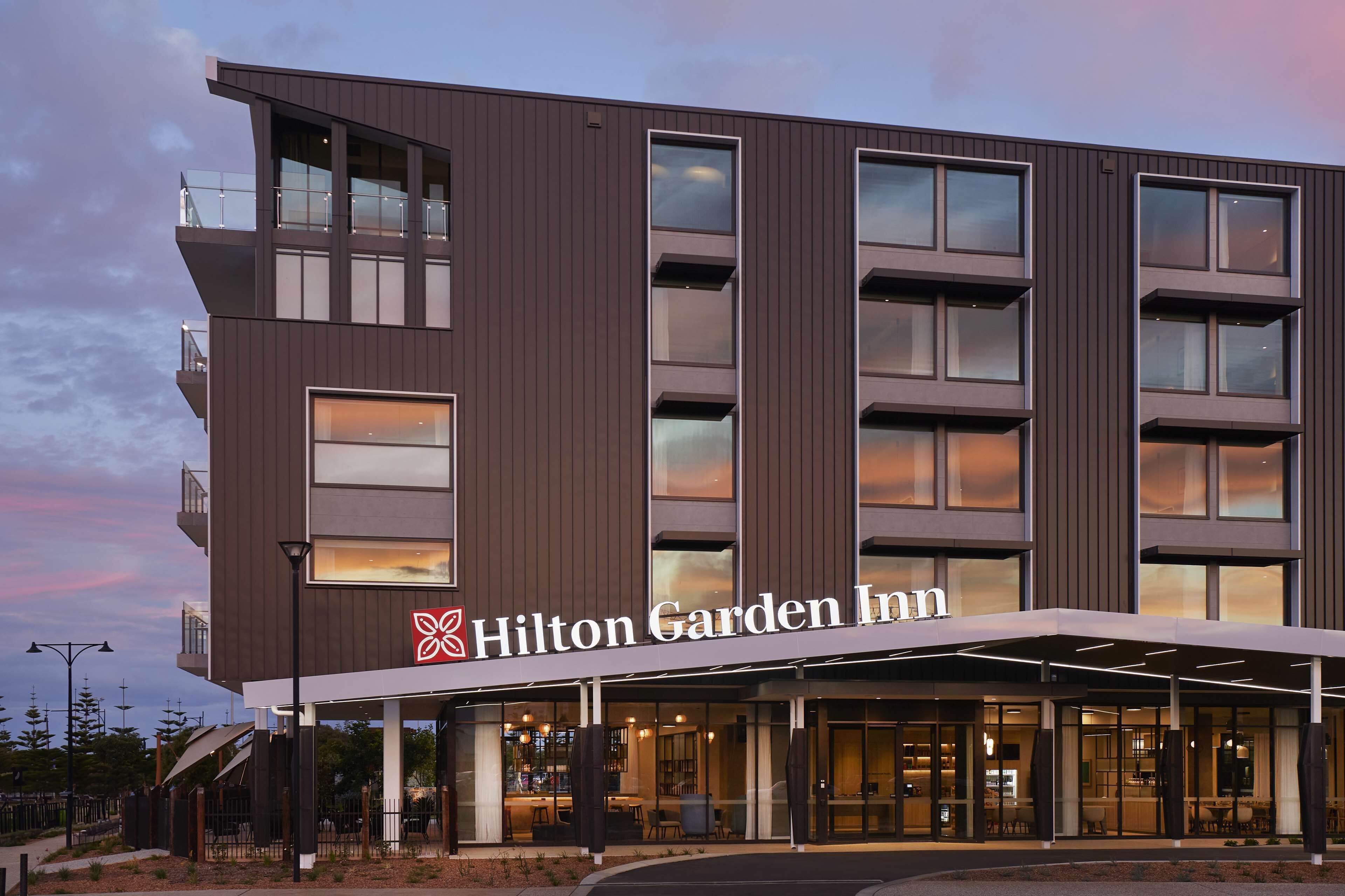 A Hilton Garden Inn hotel with a modern design, featuring a prominent entrance with a covered walkway and multiple floors with large windows.