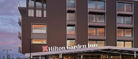 A Hilton Garden Inn hotel with a modern design, featuring a prominent entrance with a covered walkway and multiple floors with large windows.