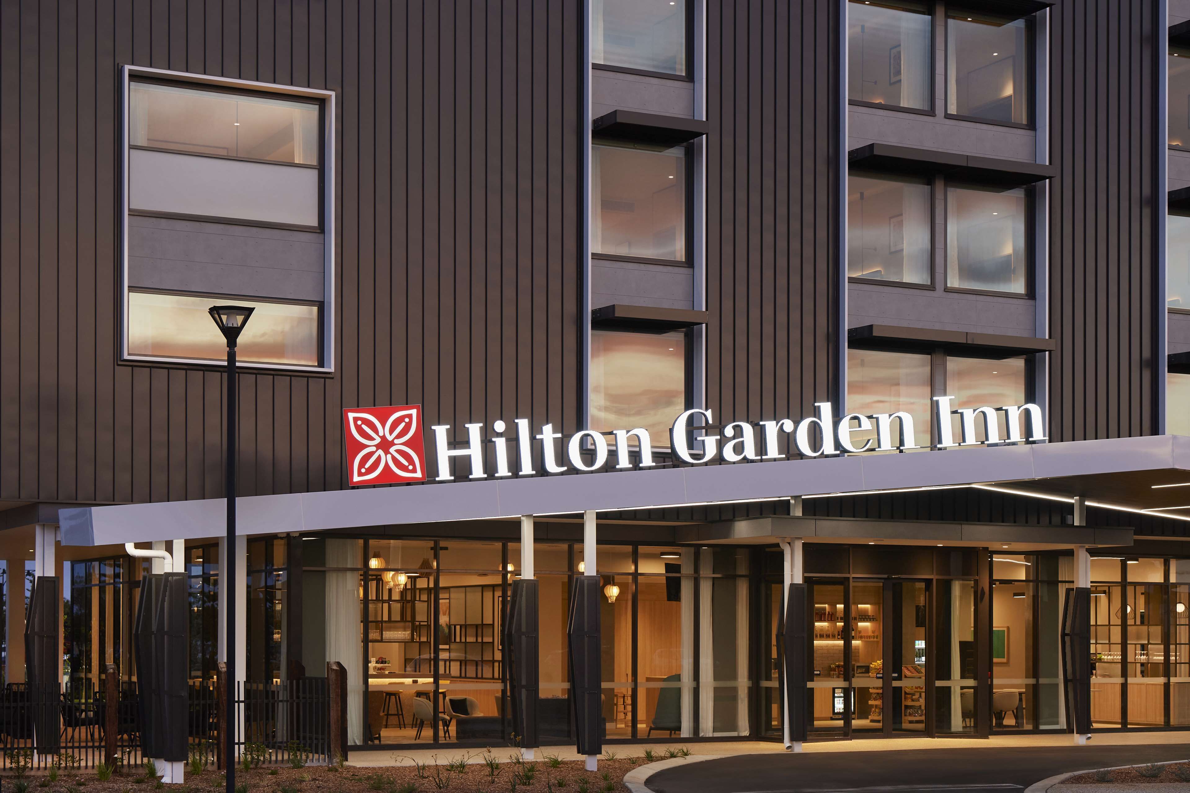 L’extérieur d’un hôtel Hilton Garden Inn, caractérisé par un design moderne, de grandes fenêtres et une enseigne bien visible.