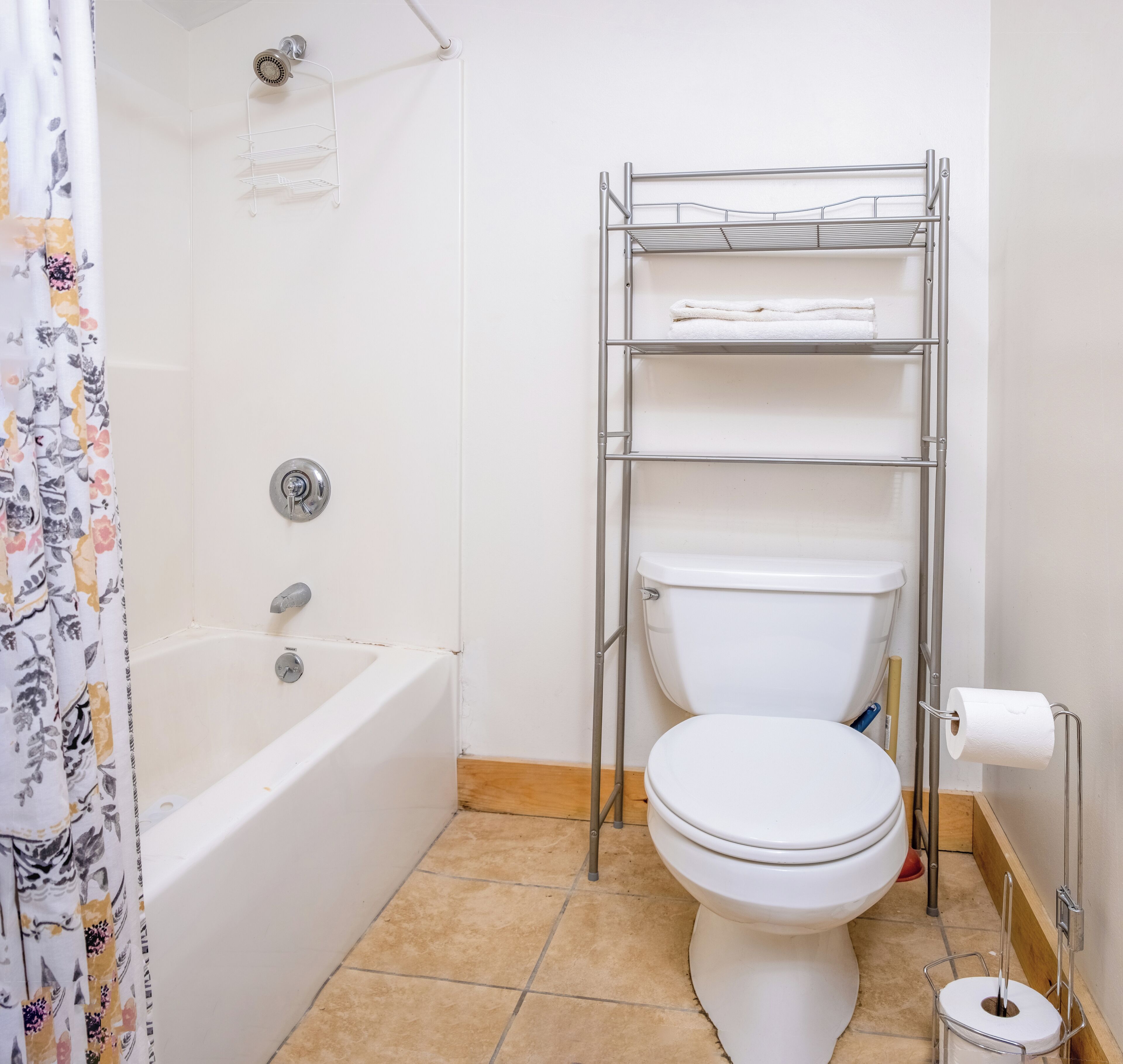 Ein Badezimmer mit einer weißen Badewanne, einer Toilette und einer Dusche.