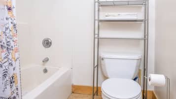Ein Badezimmer mit einer weißen Badewanne, einer Toilette und einer Dusche.