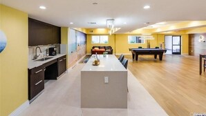 A spacious living area with a kitchen, a pool table, and a central island.