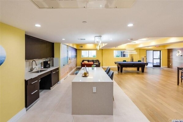 Un apartamento moderno con cocina, comedor y mesa de billar.