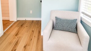 Une pièce avec un mur bleu clair, un plancher en bois, un fauteuil beige agrémenté d’un coussin à motifs, et une pancarte sur laquelle on peut lire : « DÉTENDEZ-VOUS ET RELÂCHEZ-VOUS ».