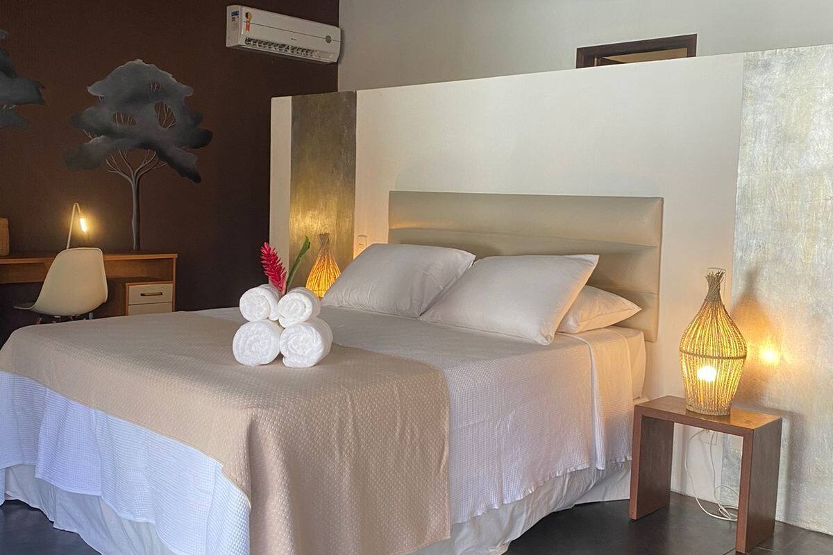 A modern bedroom with a large bed, bedside lamps, and decorative wall art.