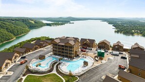 Un hotel con piscina, estacionamiento y vista al lago.