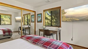A bedroom with a bed, desk, chair, and large windows with a view. - Double Black Diamond | Bear Mtn w/ Hot Tub (Big Bear Lake)