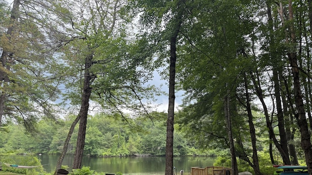A serene lakeside campsite with picnic tables, a wooden deck, and canoe storage. - Cozy Lakeside Year Round Retreat ☀️🛶 🎣 🏊 🍁 🎃 🍎 🎿🏂 ❄️  & 🐾 are welcome 😊 (Hillsboro)