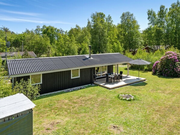 A modern house with a deck, a patio, and a garden.