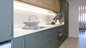 Eine moderne Küche mit Backofen, Spüle und einer Arbeitsfläche mit Wasserkocher.