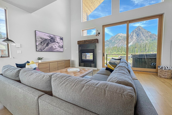 Spacious modern living room with see-thru fireplace and floor-to-ceiling view.