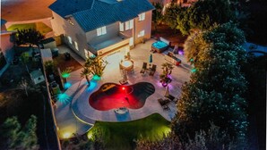 A two-story building with a swimming pool and outdoor seating area. - Resort Backyard with Pool, Spa & Putting Green (Chandler)
