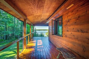 A wooden cabin with a deck overlooking a forest and a lake. - Lakefront Townsend Cabin w/ Fire Pit, Private Dock (Townsend)