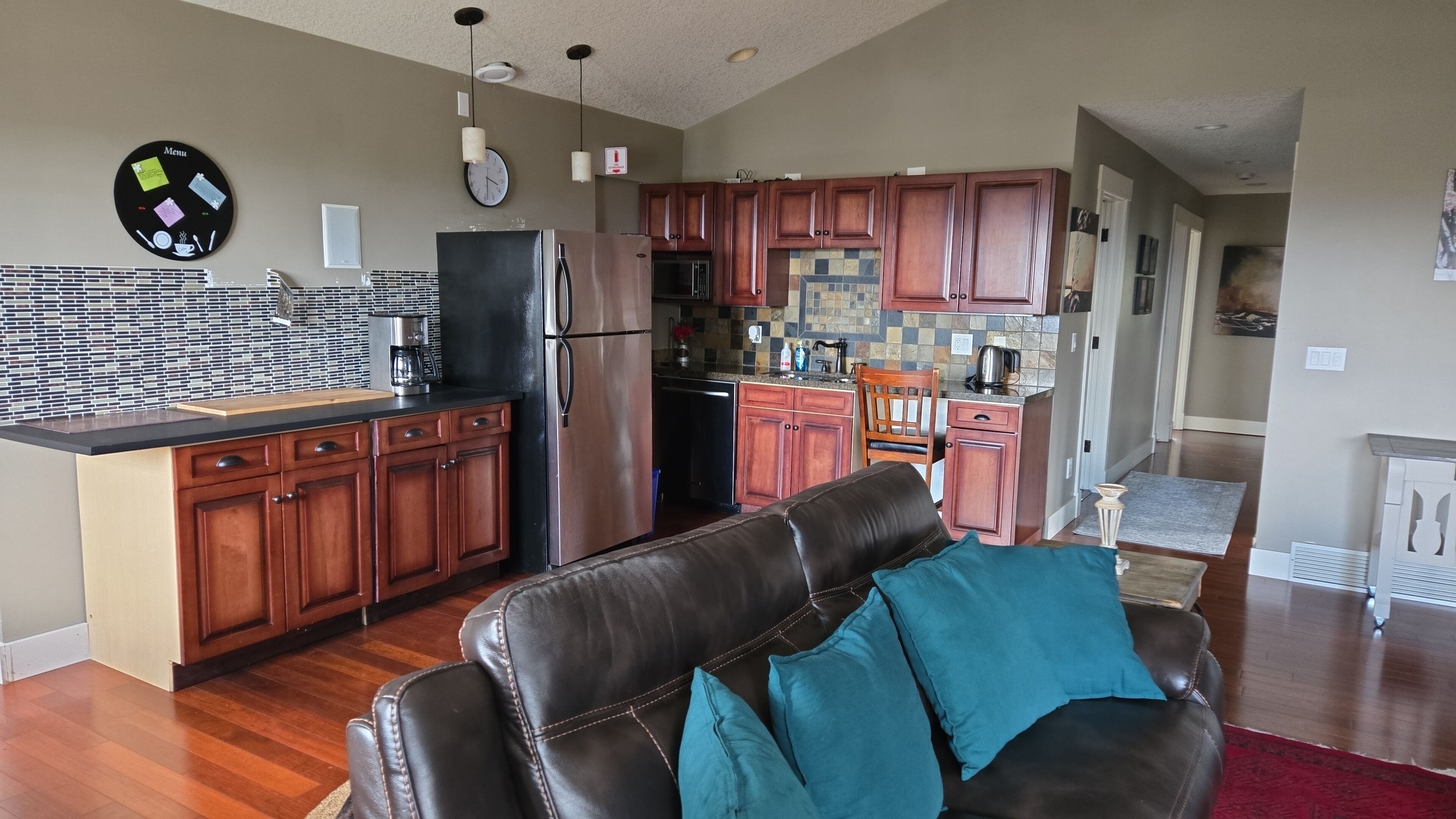 A modern kitchen with wooden cabinets, a refrigerator, and a microwave.