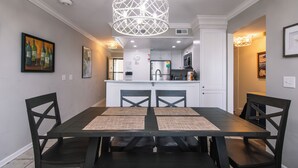 A dining area with a dark wooden table, black chairs, and a white pendant light. - 216 Bay Creek Villa-Beautiful 2nd Floor Villa;Private Balcony;Water Views;Communal Pool (Edisto Beach)