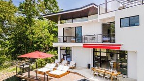 A modern two-story house with a pool, outdoor seating, and a dining area. - Elegant Modern Villa with Private Pool & Rooftop, Near Beach and City Center (Tamarindo)