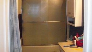 A bathroom with a shower, a towel rack, and a cabinet with toiletries. - Rhue's Haven less than 5 minutes from the most wonderful beach in NC (Sunset Beach)