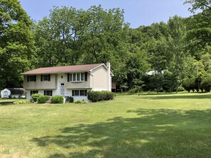 A two-story house with a front porch, a small attached garage, and a well-maintained lawn.