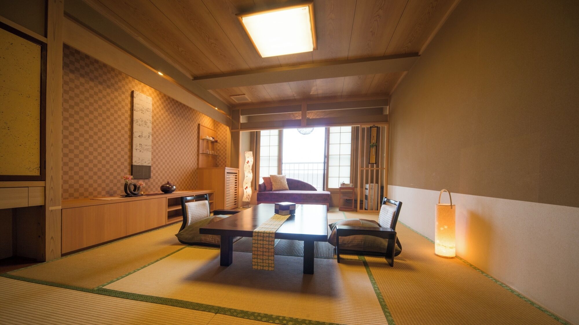 Una habitación japonesa tradicional con suelo de tatami, una mesa baja y un sofá.