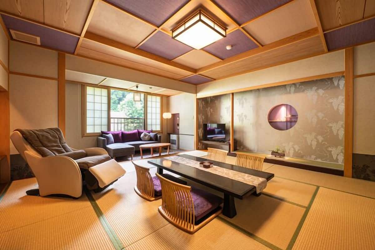 A traditional Japanese-style room with tatami flooring, a low table, and a sofa.