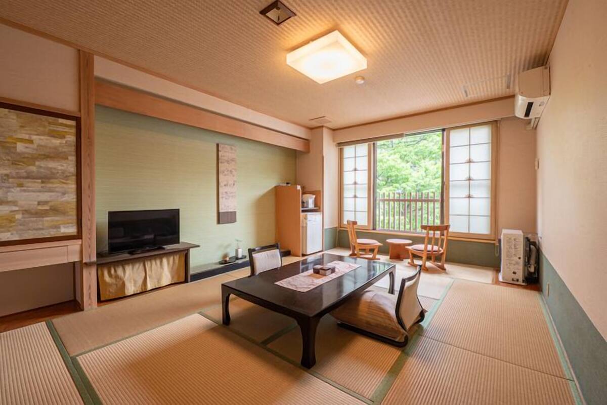 A traditional Japanese-style room with tatami flooring, a low table, and sliding doors.