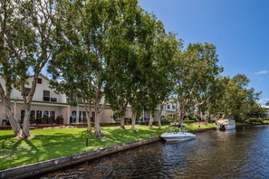 Guests can enjoy serene riverside views from the balconies of these two-story buildings, surrounded by lush greenery and well-maintained lawns.