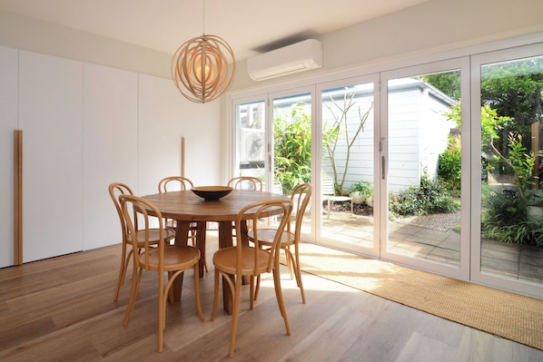Enjoy meals in this dining area with a round table and six chairs, surrounded by a garden view.