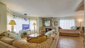 A living room with a sofa, a TV, a fireplace, and a bed. - 50 ft from the SAND 30 seconds (Del Mar)