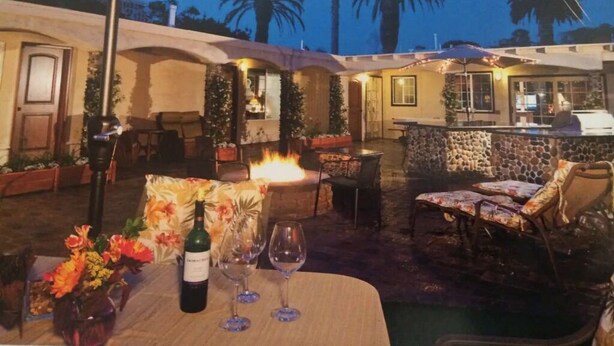 An outdoor patio with a fire feature, seating, and a bar area. - 50 ft from the SAND 30 seconds (Del Mar)
