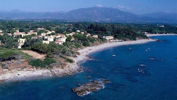 A coastal town with buildings along the beach and mountains in the background. - Beach access main floor T3 apartment with amazing patio and plenty of space!  (Linguizzetta)