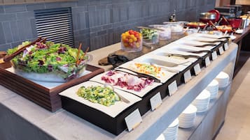 Un buffet proposant une variété de plats et d’ustensiles de service.