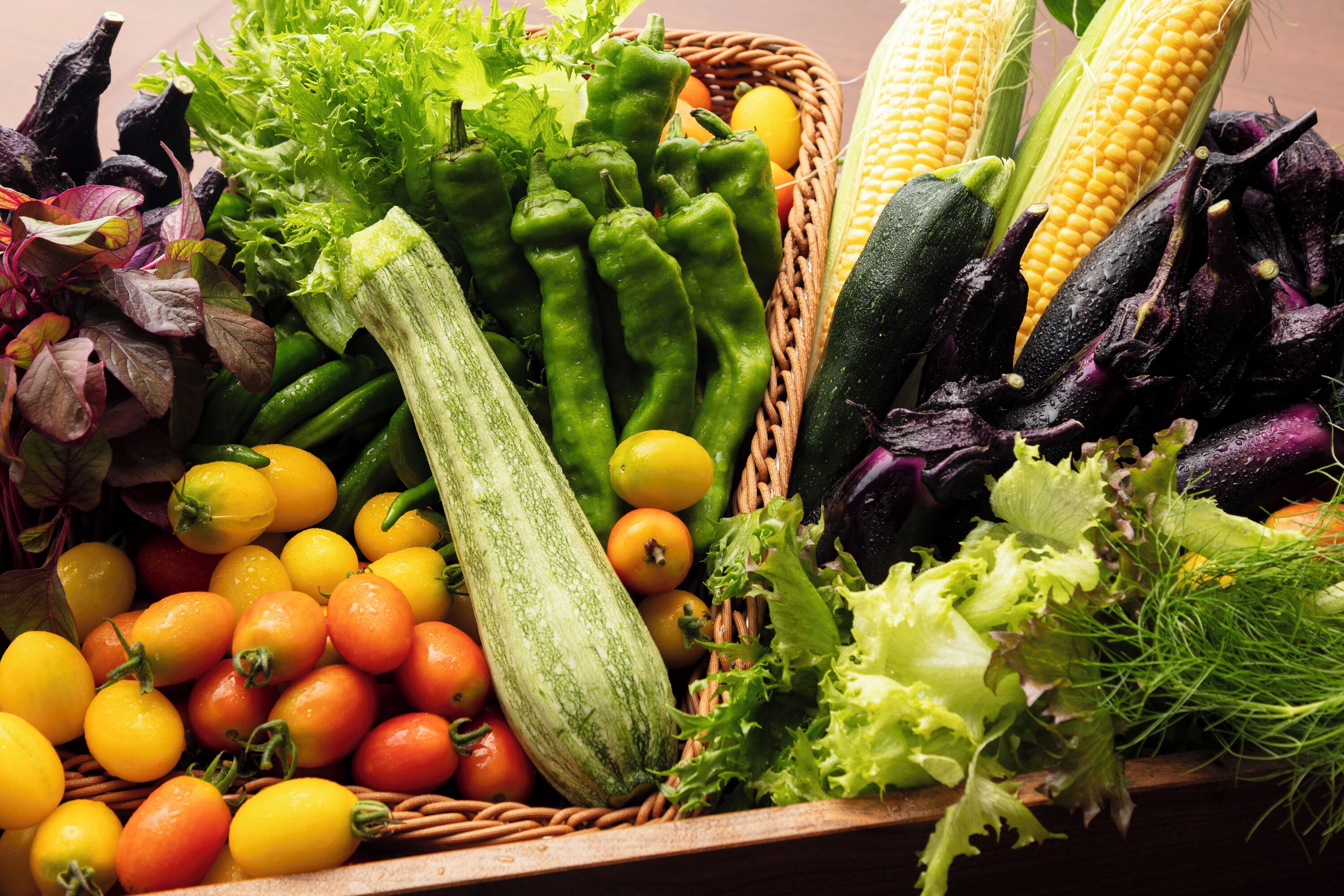 A variety of fresh vegetables including corn, zucchini, and tomatoes.