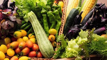 A variety of fresh vegetables including corn, zucchini, and tomatoes.