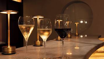 Three glasses of wine on a bar counter with a modern, minimalist design.