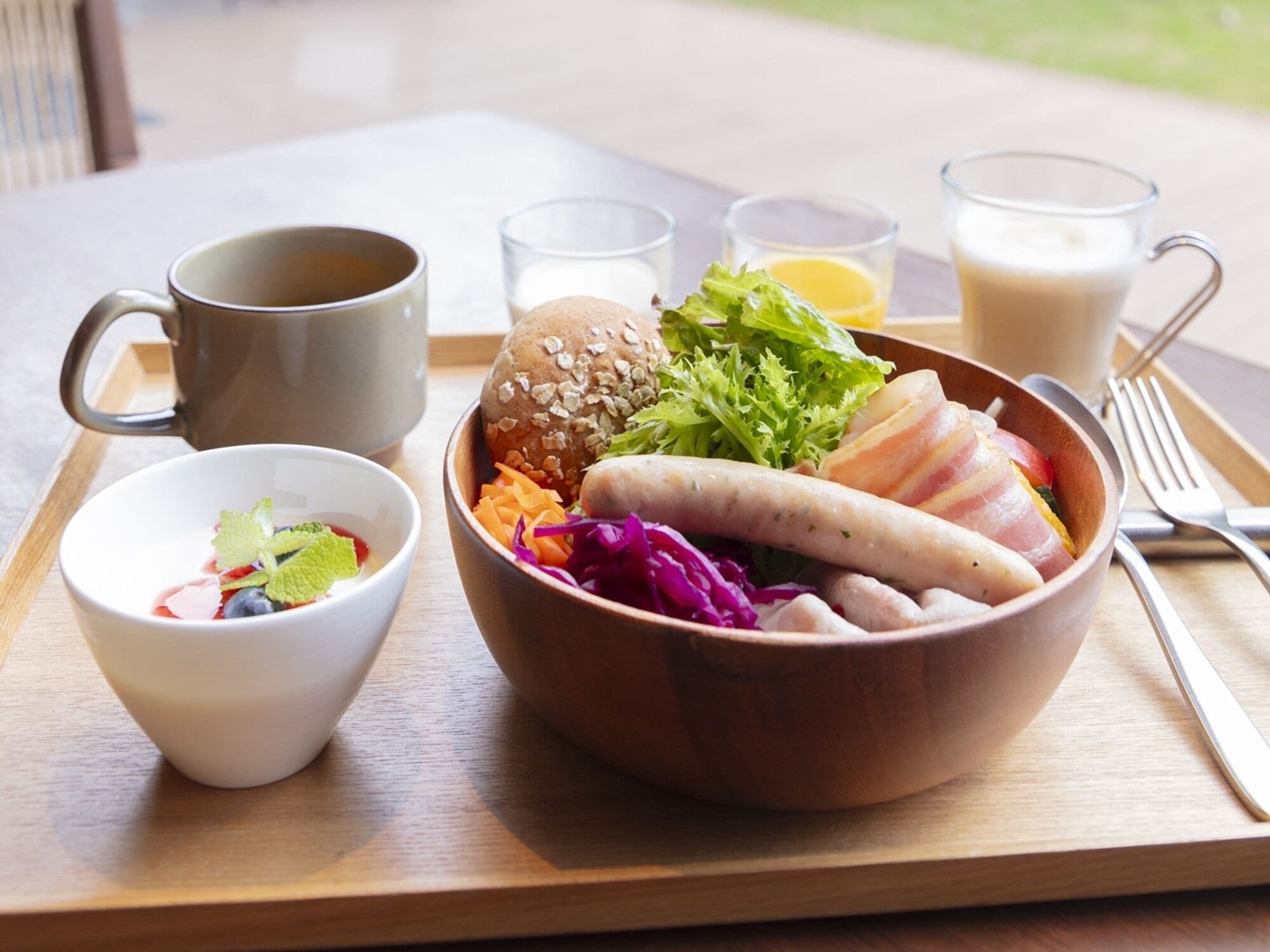 A meal tray with a bowl of food, a cup of coffee, and a glass of milk.