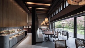 Een modern restaurant met een lange toonbank, een zithoek en grote ramen met uitzicht op het landschap.