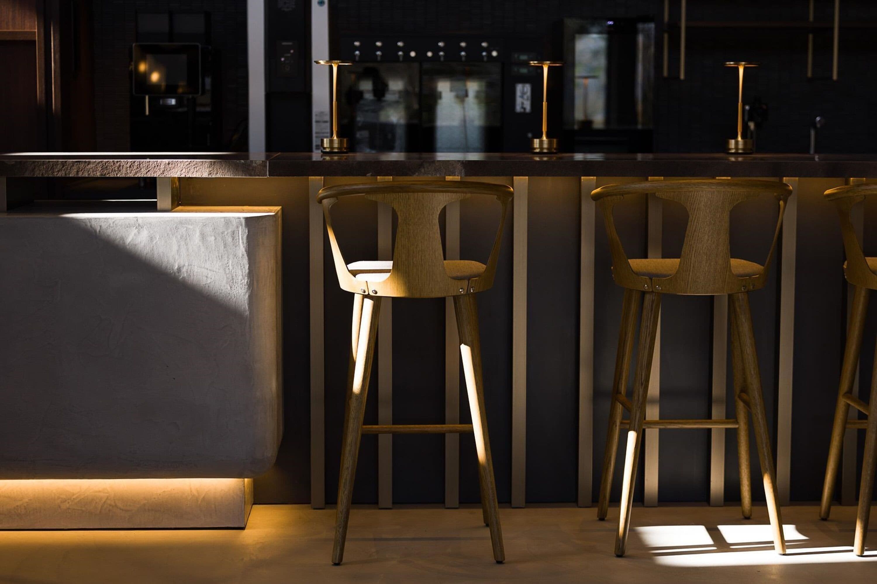 A bar area with a counter and three stools.
