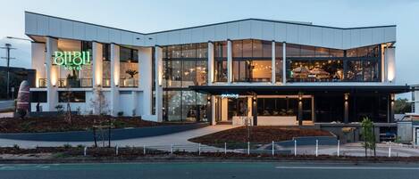 A modern hotel with a prominent gaming area, large windows, and a well-lit entrance.