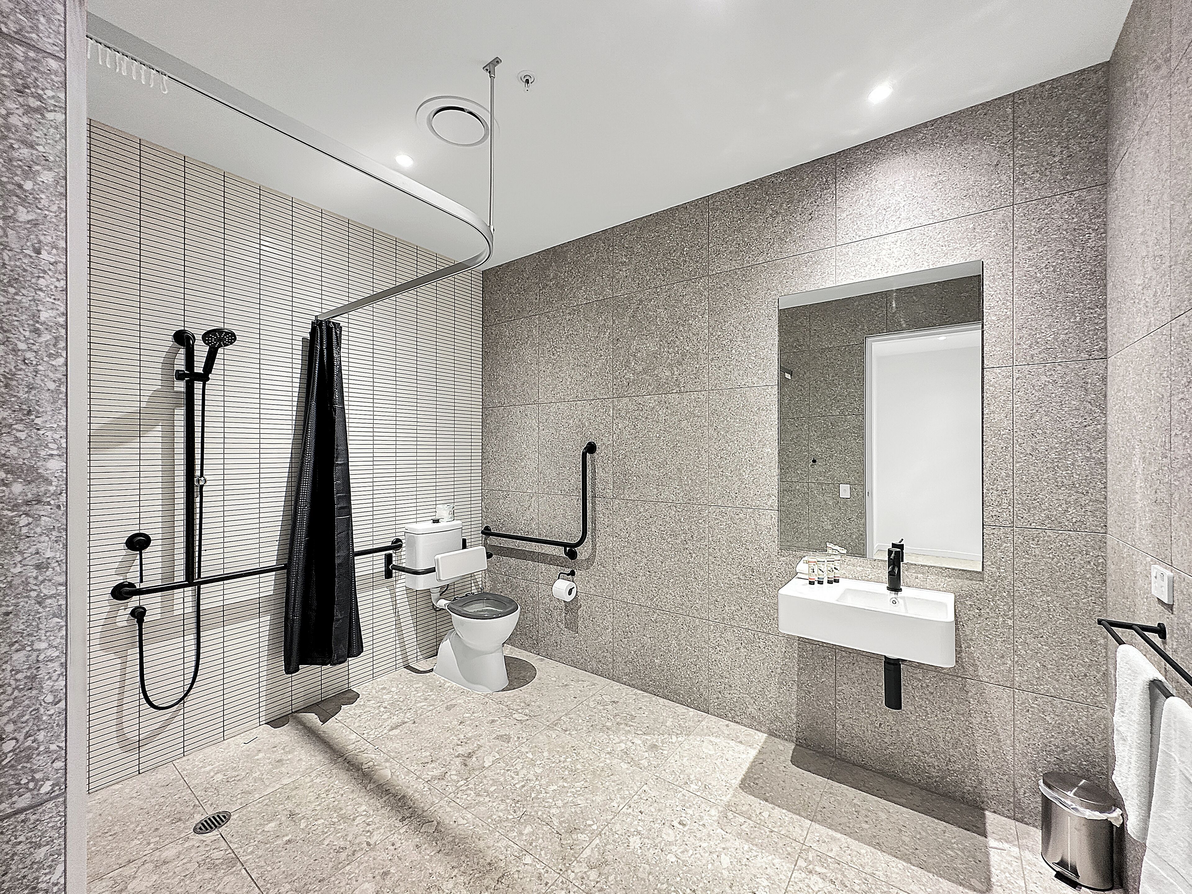 Un baño moderno con ducha, inodoro y lavabo.