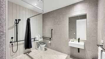A modern bathroom with a shower, toilet, and sink.