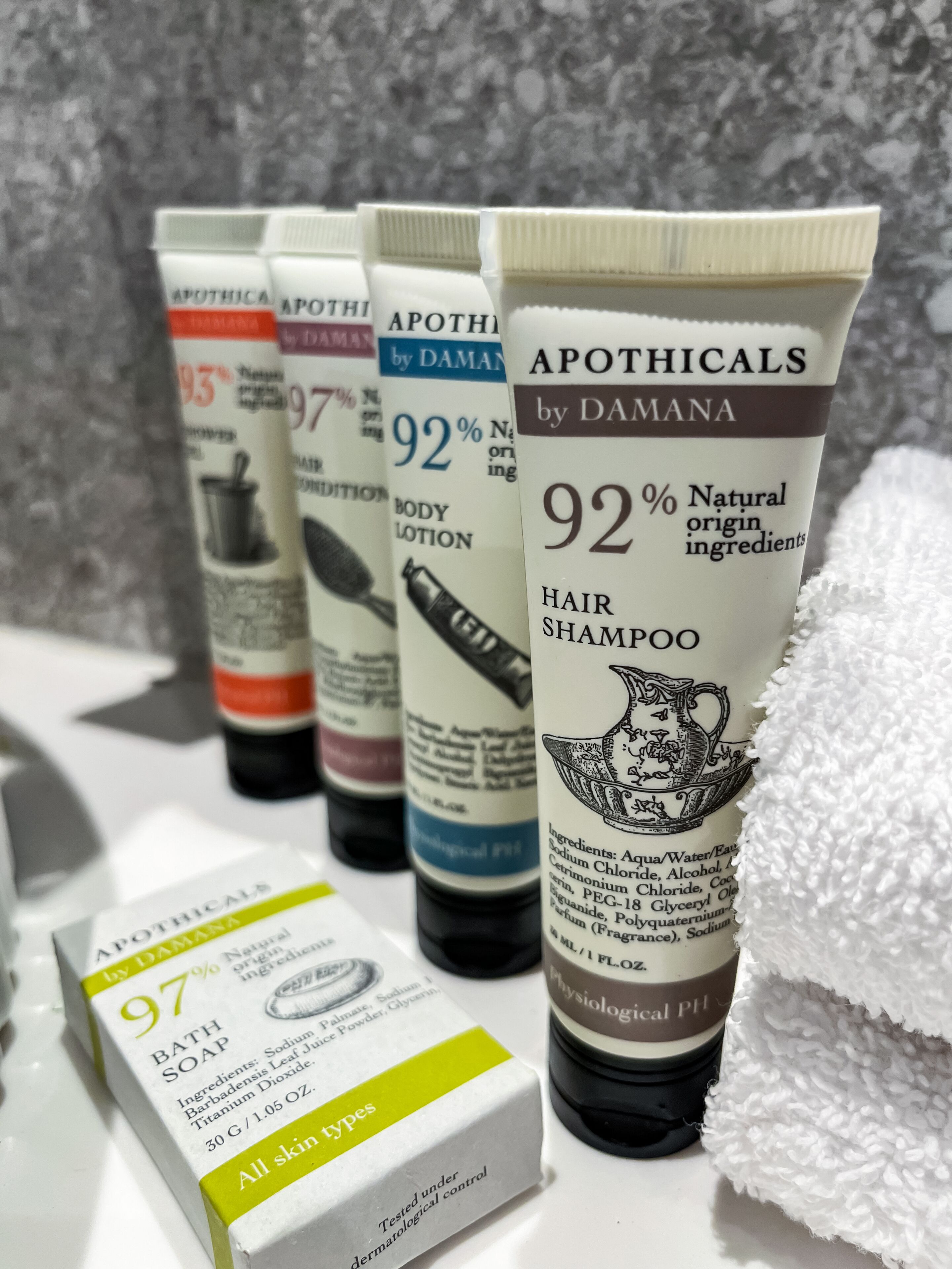 A row of toiletries including a hair shampoo, body lotion, and bath soap, all labeled with 92% natural ingredients.