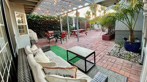 A covered outdoor patio with a sofa, chairs, and a table.
