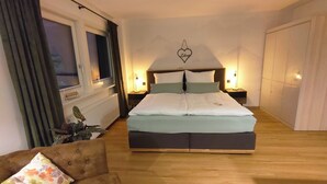 A bedroom with a bed, bedside tables, a window, and a plant. - Studio apartment for 2 persons with terrace, 34 m² (Inzell)